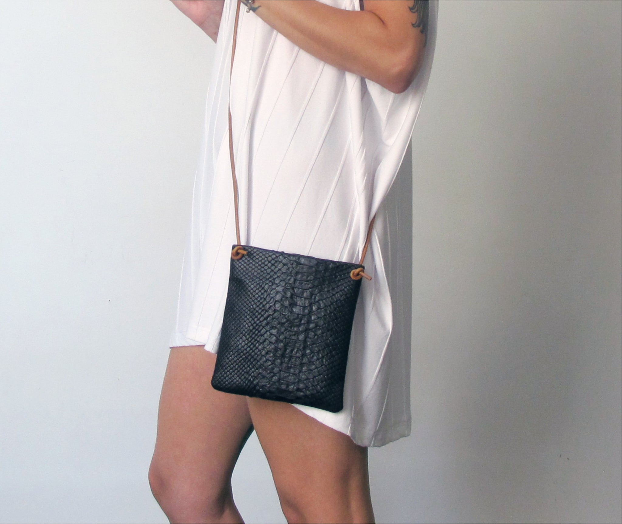 The black python purse is crafted in rich Italian leather with an adjustable & detachable shoulder strap to carry it crossbody or as an evening clutch. 