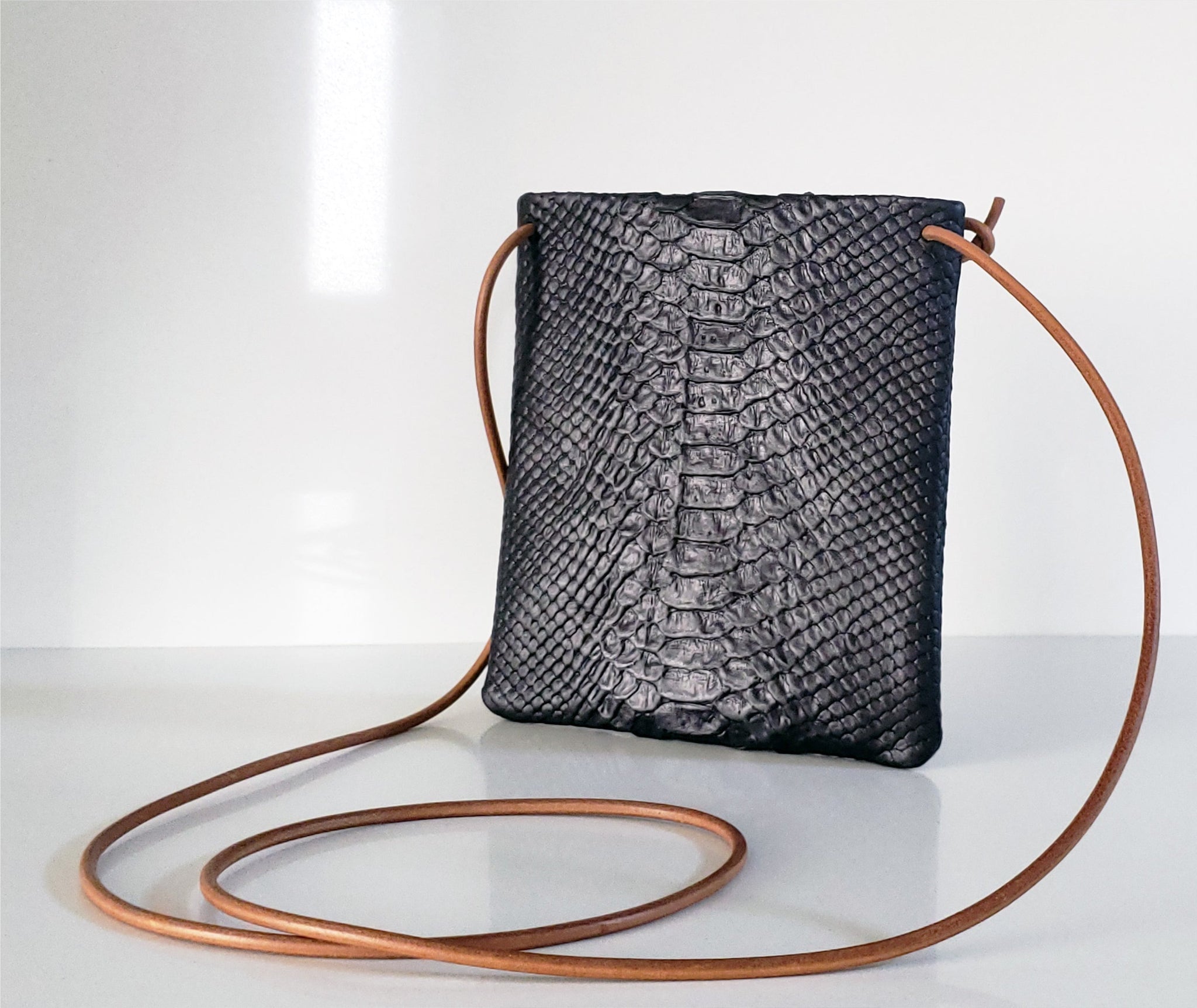 The black python purse is crafted in rich Italian leather with an adjustable & detachable shoulder strap to carry it crossbody or as an evening clutch. 