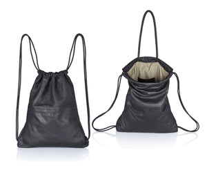 Black multi-way leather drawstring backpack crafted with soft Italian Napa leather, adjustable back straps, and leather-covered inner top handles. This style is versatile and can be carried as a backpack, tote, or on the shoulder. Its ideal minimalist design is suitable for long active days & use. Suitable for laptops up to 15inch.