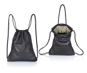 Black multi-way leather drawstring backpack crafted with soft Italian Napa leather, adjustable back straps, and leather-covered inner top handles. This style is versatile and can be carried as a backpack, tote, or on the shoulder. Its ideal minimalist design is suitable for long active days & use. Suitable for laptops up to 15inch.