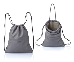 Gray multi-way leather drawstring backpack crafted with soft Italian Napa leather, adjustable back straps, and leather-covered inner top handles. This style is versatile and can be carried as a backpack, tote, or on the shoulder. Its ideal minimalist design is suitable for long active days & use. Suitable for laptops up to 15inch.