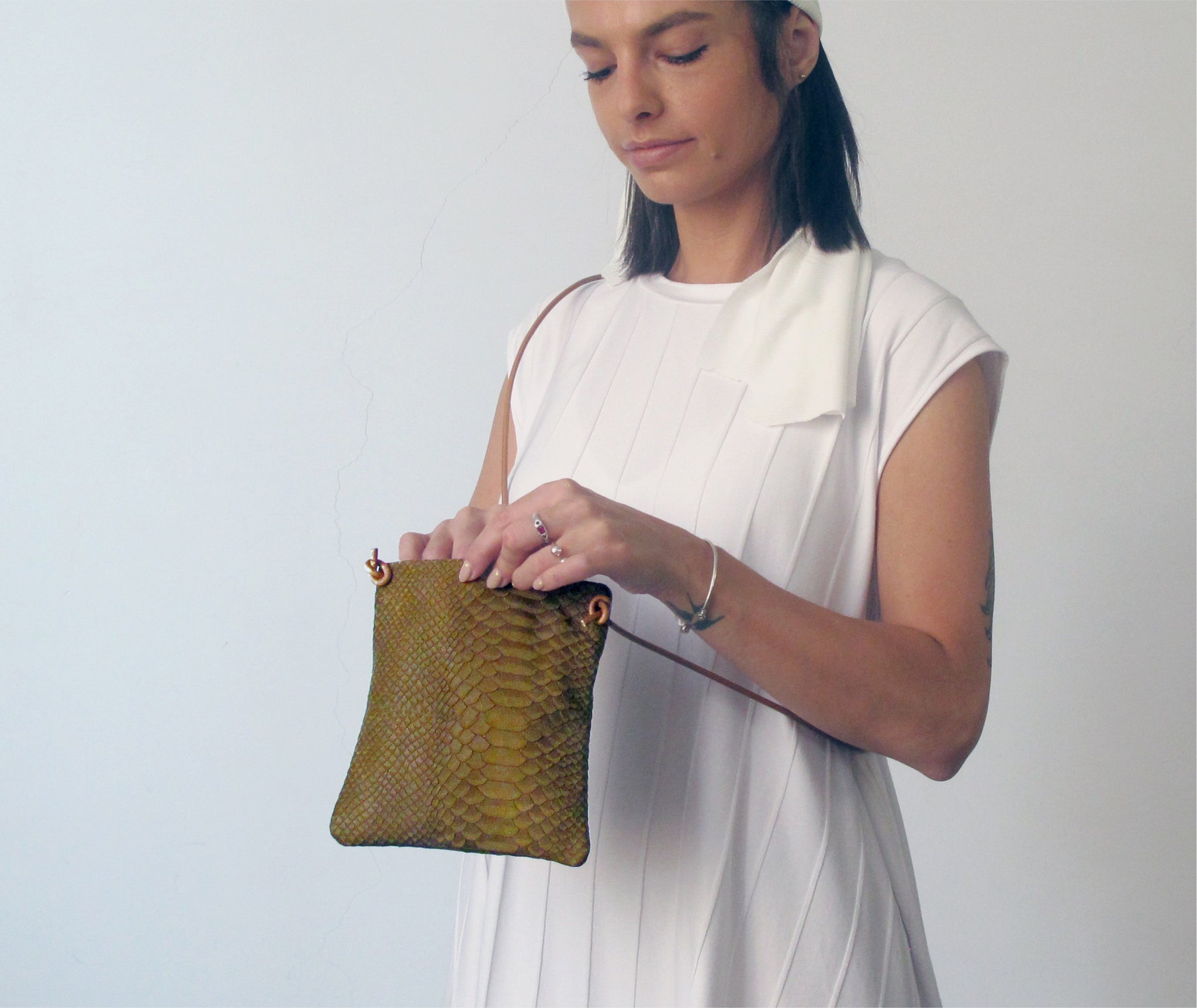 The olive green python purse is crafted in rich Italian leather with an adjustable & detachable shoulder strap to carry it crossbody or as an evening clutch.