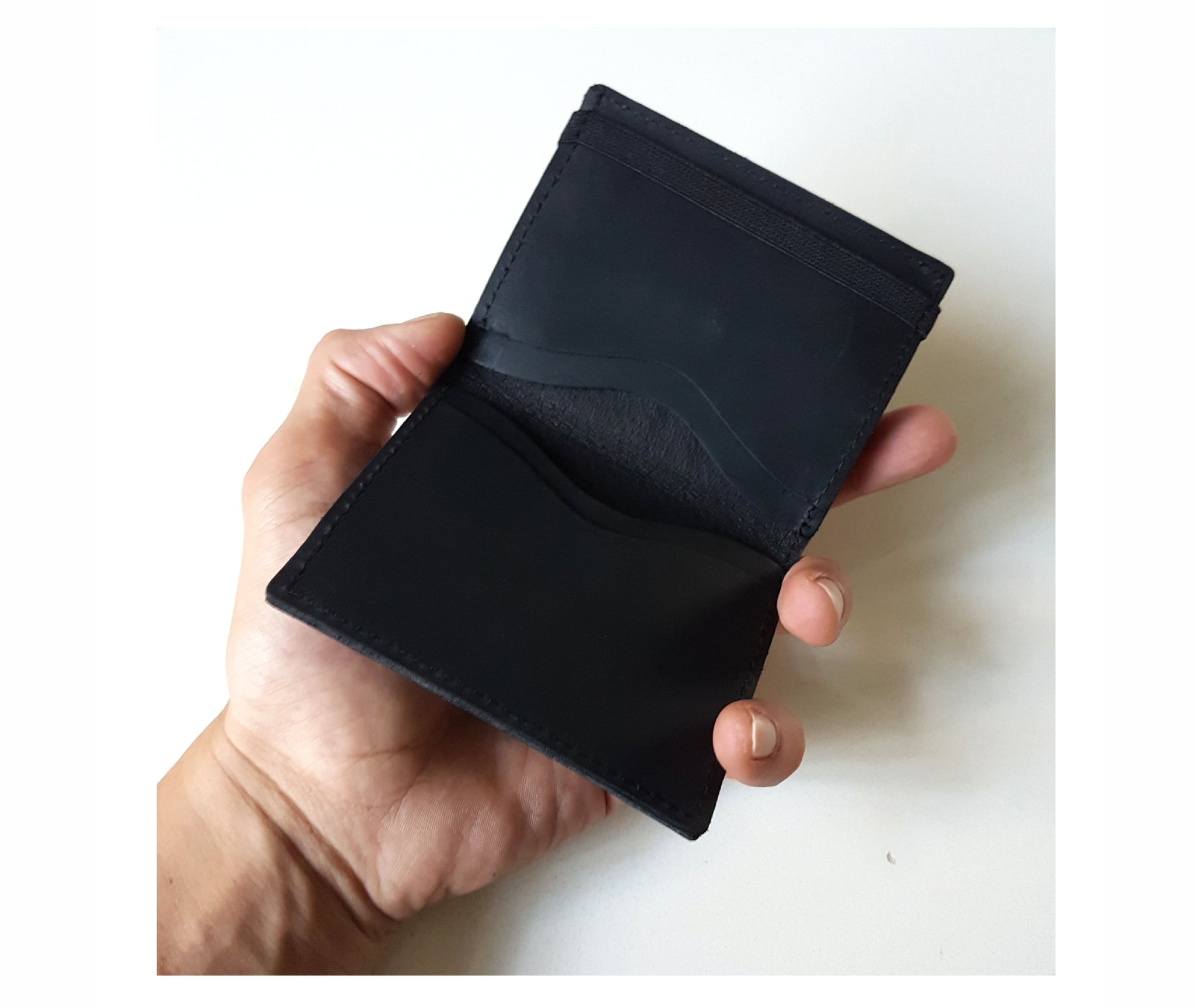 Black handmade Italian leather bifold wallet with a unique metal clip for bills and a coins pocket. The perfect lightweight slim wallet, cards wallet, and gift for men.